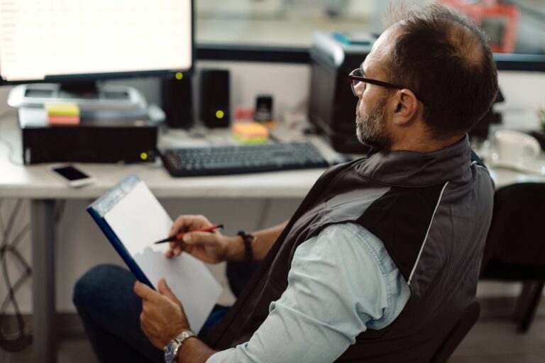 an HVAC business owner looks HVAC insurance paperwork