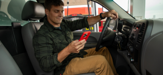 an HVAC worker uses a mobile phone with WEX FSM for social media marketing for hvac business