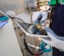 Close up hand engineer working use digital tablet report or analysis AI manufacturing system industrial plant. Environment technician check clean air pollution reduction for sustainable ESG.Electrical