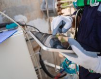 Close up hand engineer working use digital tablet report or analysis AI manufacturing system industrial plant. Environment technician check clean air pollution reduction for sustainable ESG.Electrical