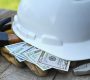 Hard hat with construction tools and cash money - concept for building cost or fraud, scam, bribes