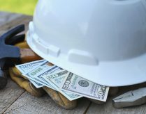 Hard hat with construction tools and cash money - concept for building cost or fraud, scam, bribes