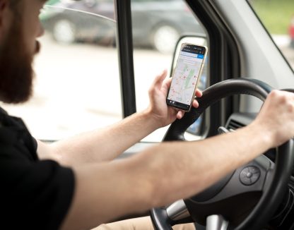 hvac plumber technician using mobile device gps and telematics for field service while driving work vehicle