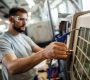 Close up of worker operating an industrial machine in a factory.