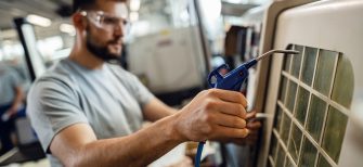 Close up of worker operating an industrial machine in a factory.