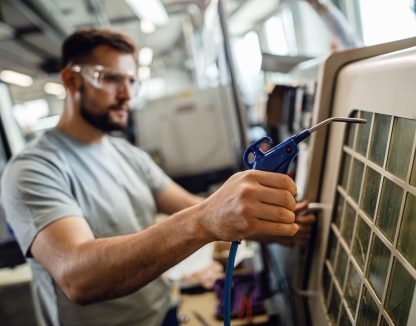 Close up of worker operating an industrial machine in a factory.