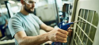 an hvac technician working on an ac unit