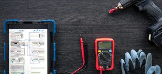 Composition with digital tablet and electrician work items, top view.