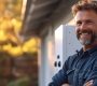 Electrician smiling and installing a home car electric charge.