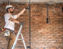 Electrician with tools, working on a construction site. Repair and handyman concept. House and house reconstruction. SSUCv3H4sIAAAAAAAACpyRz27DIAzG75P2DhHnRmr+ttmrVDs44CaoFCogm6aq7z4DYeK8G/7Z/uzPPN/fqorN4CRnH9UzRBRLpTbnLXhpNOHjYecWtUBbEhTSGytBlXAGz1cNdySoN6UCfsUkcx785tCFYTvi4HEhjQT/JNJGlxRXORGT1EEpxg4Fc9scWUZJ/F+d6fGZ3cCCmv/EhQsjFhVCMnJJpez27dHeS2uwCWkKV1+GgwoFXaH0sJJLvRRtxq/xyrmNm017G1ZgbTPl5Zky5gGzCle+kixmvoJz1CEyL2Zx+lZzL0Zp46OH/SRM0GeEsOnapm+HYTr14+lEUbcXpA9cJenEjbIQxfwmRelehg3YNJ6vneBT3R3bse4HMdZwPkLNkUPTNu25GZBu//oFAAD//wMAxplQV4oCAAA=