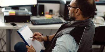 an HVAC business owner looks HVAC insurance paperwork