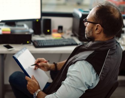 an HVAC business owner looks HVAC insurance paperwork