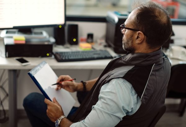 an HVAC business owner looks HVAC insurance paperwork