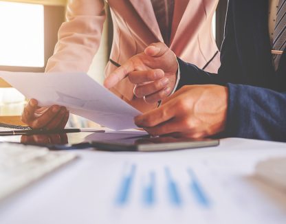 Business concept. Business people discussing the charts and graphs showing the results of their successful teamwork. Selective focus.