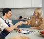 male-plumber-working-with-client-fix-kitchen-problems