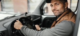 an hvac plumbing technician wearing a vest drives a work van, the text reads customer spotlight: how Leigh's heating and cooling succeeds with WEX FSM