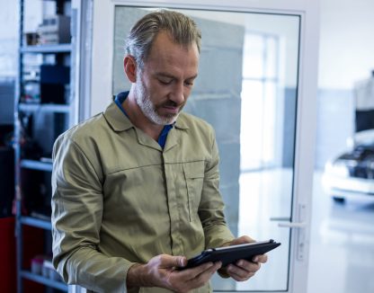 Mechanic using digital tablet in repair shop