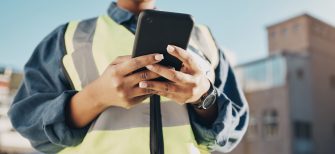 Phone, construction worker hands and person typing, networking or search info about inspection, maintenance or building. Cellphone communication, closeup builder or engineer research architecture.