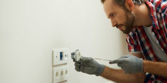 Portrait of electrician wearing protective gloves, using a screwdriver while installing new plug socket in a house. Electrical maintenance, repair service concept SSUCv3H4sIAAAAAAAEAH2Rz04DIRDG7ya+w4ZzN1lbKru+g9F742GAsYul0PBH0zR9d2EpysF4Y37fzAcfc7m/6zrCwStBnrpLrlKttI4+OAjKmoSH1Y07NBJdS1CqYJ0C3UIOQcwGjpigiVpnfF1E4gOE6NHny25IQMB98ijwx6K8aFfqrgqLmCaSRF7RnjSSVaP4yLPyjIZUel39Y/HCP1AE/6eH8gK1BoM2+l+3cnirUWGPRpyXNE1KhxqhpNyVVnL4CuiObW6IUtkm8qcVoHPDpnE6OSWU2TdjNszLCuqYsNEEl59AagyirT0B1/n/35MnVj6D96ldVt5cJNLC7bG5x9iwBLi5EpnWlMuHzXq7ptM4PI7baZzYSEldrRUHJduIZduzSpI7N1zlFxBKx4kDoz1bA+upHFjPcQv9o2AIfKI4MJk+/voN5K/JfaQCAAA=