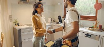 A plumber shakes hands with a homeowner