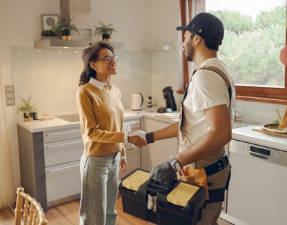 A plumber shakes hands with a homeowner