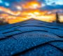 A roof with a sunset in the background.