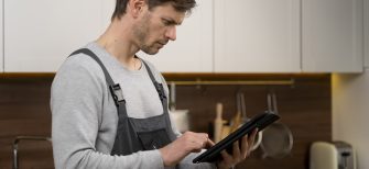 A field service worker using a mobile device to service and create pricebooks for jobs with WEX FSM